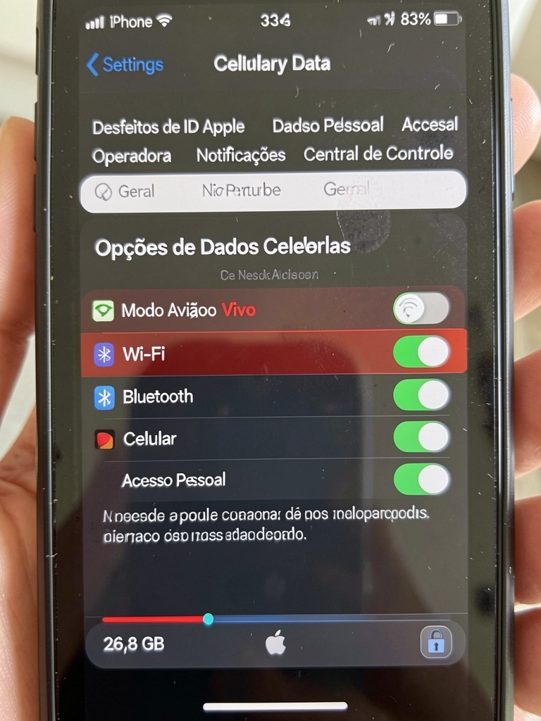 Smartphone sobre mesa de madeira exibindo tela com ícones de conexão e sinal Wi-Fi, ao lado de um notebook aberto.